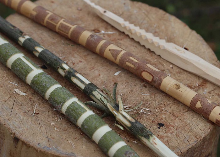 Trollstavar tillverkade av träpinnar ligger på en stubbe.